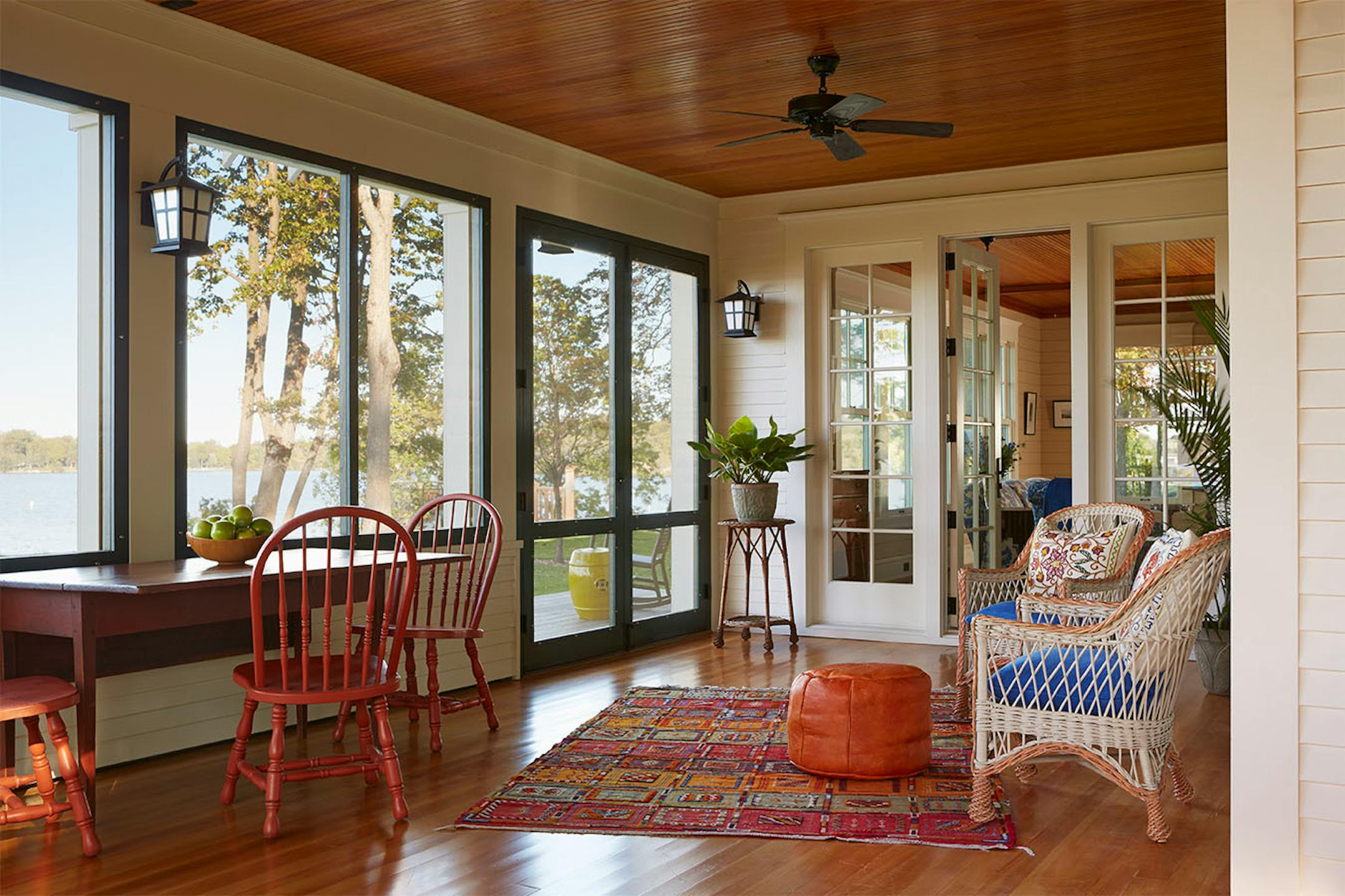 Old-fashioned screen porch wraps around two sides of the cottage facing Lake MInnetonka.