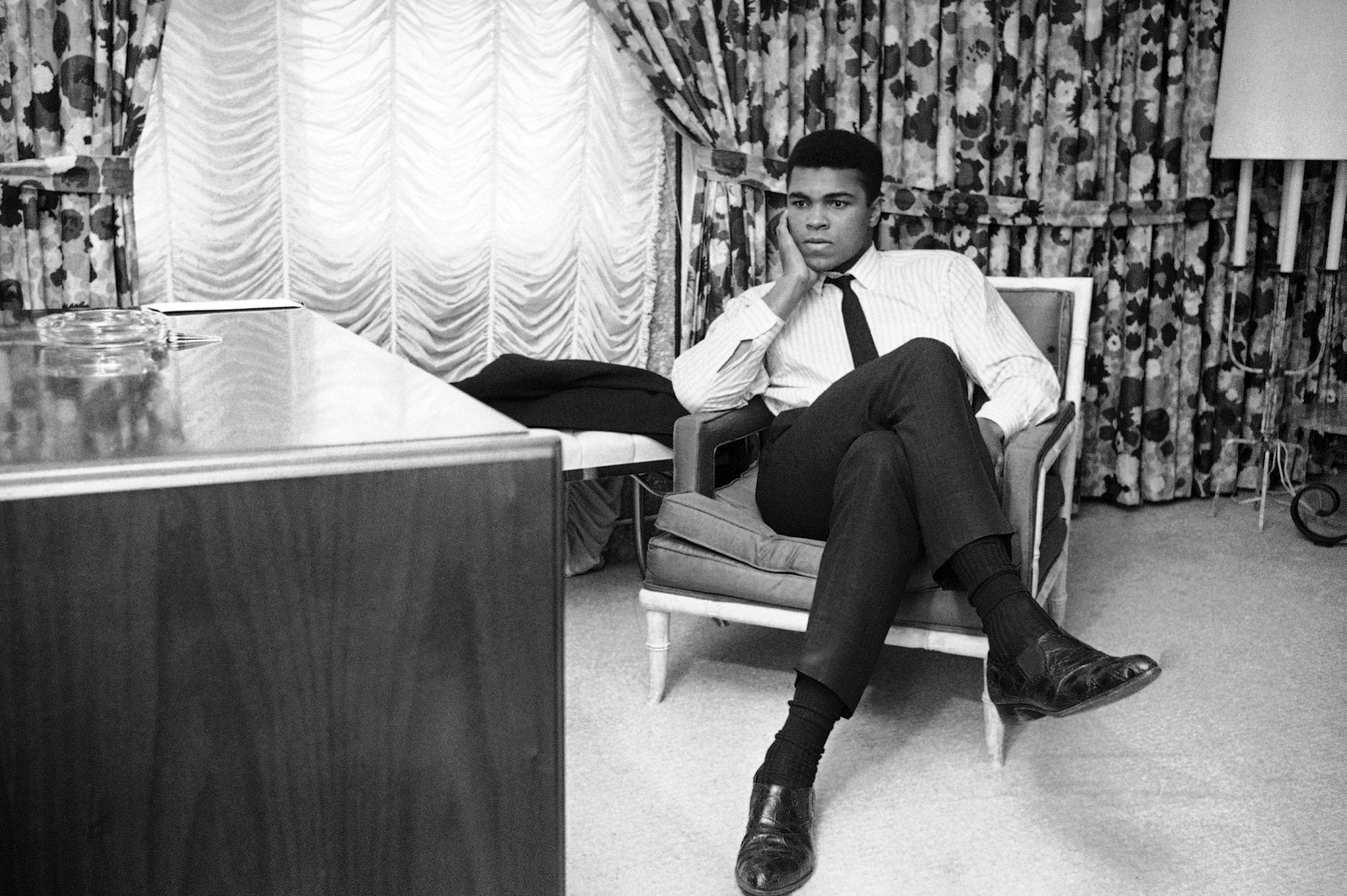 World heavyweight champion Muhammad Ali sits in his room on his arrival in Houston, Feb. 20, 1967. The champ was silent on his thoughts about his draft status referring all questions to his New York attorney. The Houston Selective Service appeals board refused his appeal for a deferment. He was trying for a deferment on grounds that he is a Muslim minister. Ali starts training tomorrow for his title defense against Zora Folley on March 22 in New York. (AP Photo/Ed Kolenovsky) ORG XMIT: APHS28239
