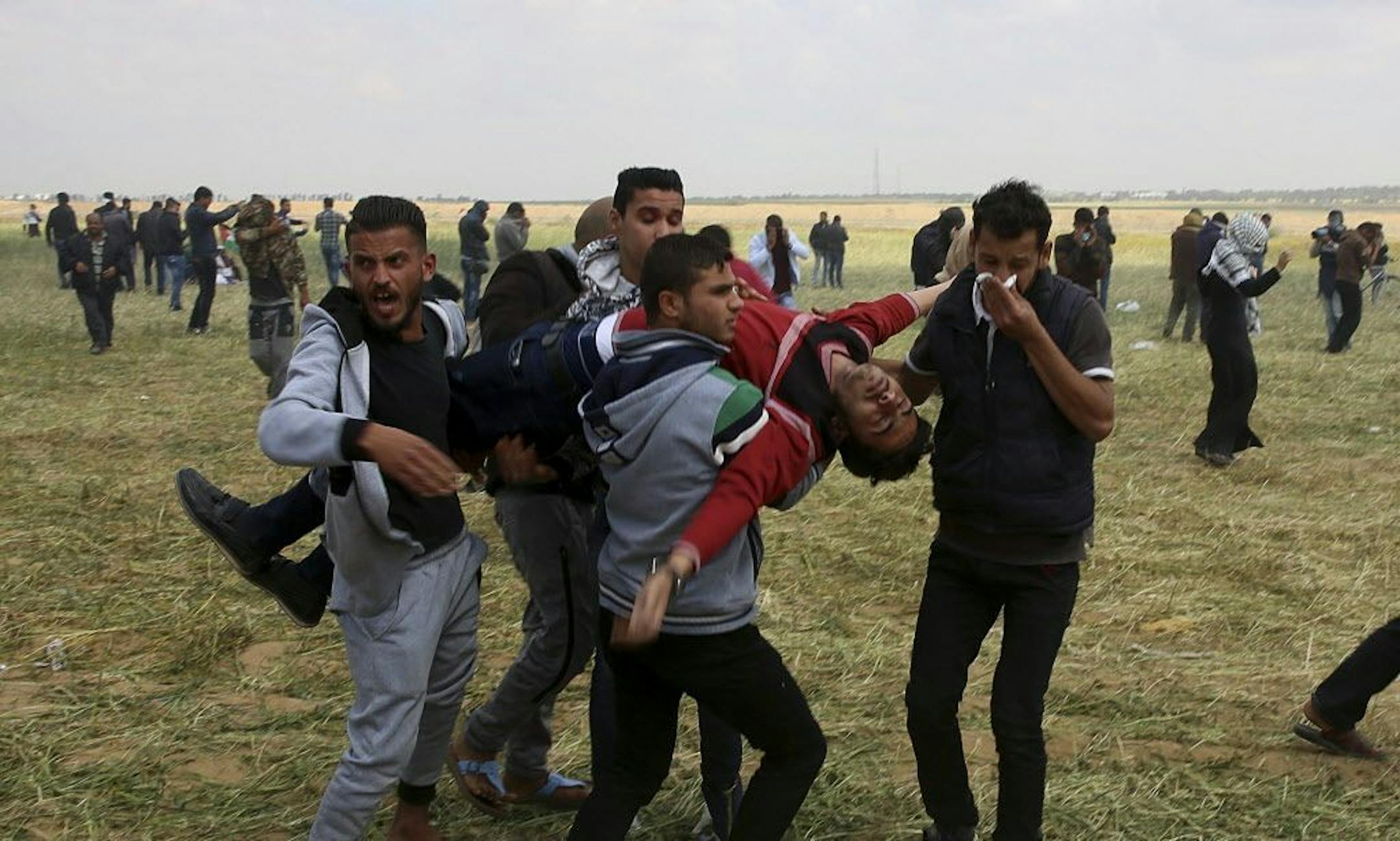 Palestinian protesters evacuate a wounded youth during clashes with Israeli troops along the Gaza Strip border with Israel, east of Khan Younis, Gaza Strip, Friday, March 30, 2018.