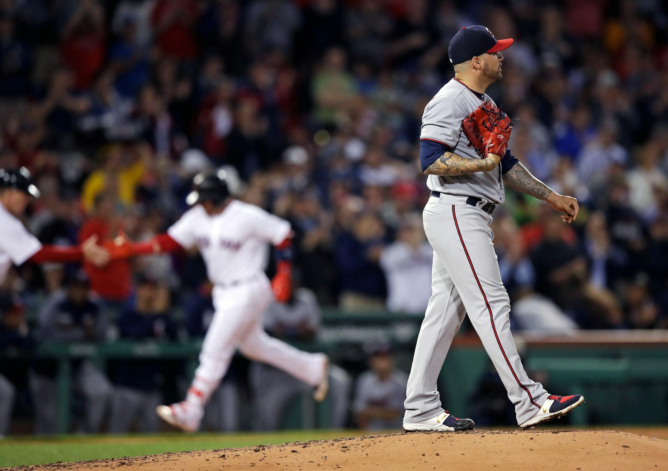 Minnesota Twins starting pitcher Hector Santiago, right, walks up the mound as Boston Red Sox's Christian Vazquez rounds the bases on a two-run home run during the second inning of a baseball game at Fenway Park in Boston, Tuesday, June 27, 2017. (AP Photo/Charles Krupa)