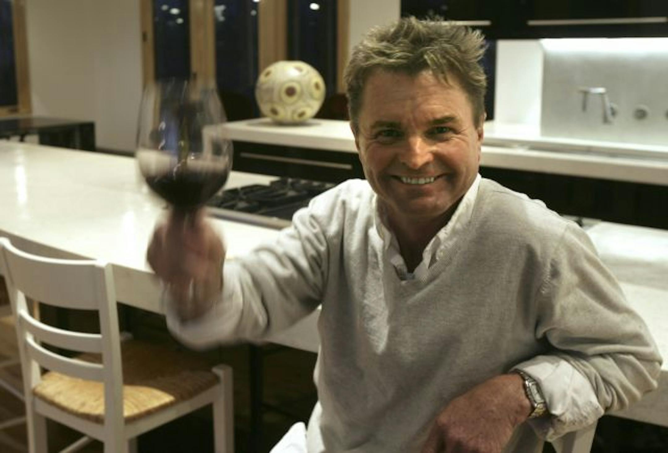 Winemaker Billy Smith lifts a glass in the kitchen of his new home.