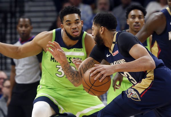New Orleans Pelicans' Anthony Davis, right, drives as Minnesota Timberwolves' Karl-Anthony Towns defends in the first half of an NBA basketball game S