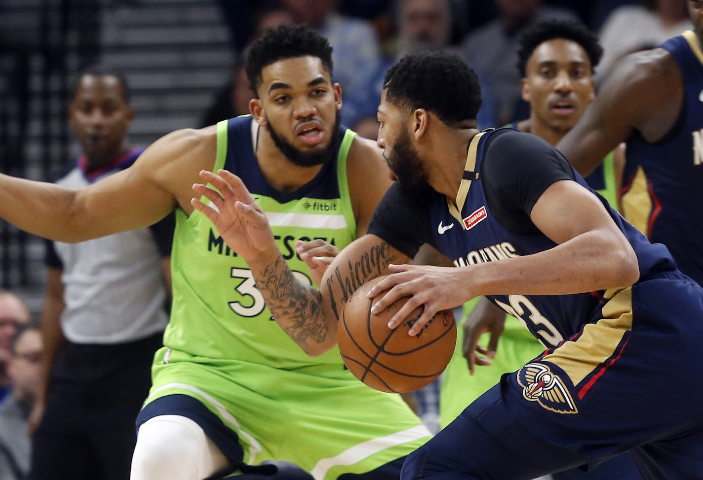 New Orleans Pelicans' Anthony Davis, right, drives as Minnesota Timberwolves' Karl-Anthony Towns defends in the first half of an NBA basketball game Saturday, Jan. 12, 2019, in Minneapolis. (AP Photo/Jim Mone)