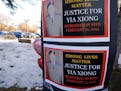Signs bearing the photo of Yia Xiong were posted Sunday, Feb. 19, 2023, near the St. Paul apartment complex where the 65-year-old was shot and killed 