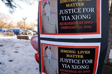 Signs bearing the photo of Yia Xiong were posted Sunday, Feb. 19, 2023, near the St. Paul apartment complex where the 65-year-old was shot and killed 