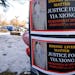 Signs bearing the photo of Yia Xiong were posted Sunday, Feb. 19, 2023, near the St. Paul apartment complex where the 65-year-old was shot and killed 
