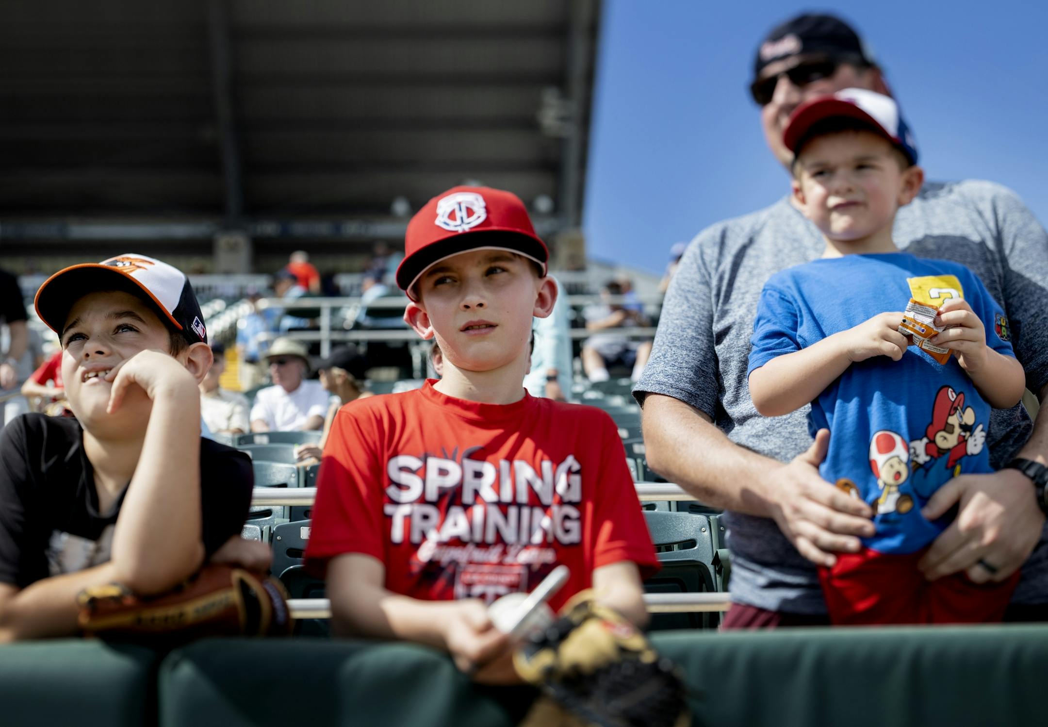 Isaac Baker, 10, of Fort Myers, Parker Swoverland, 11, of Medina, Minn. and Dayden Fulghum, 3, watched the Minnesota Twins first day of practice for position players.