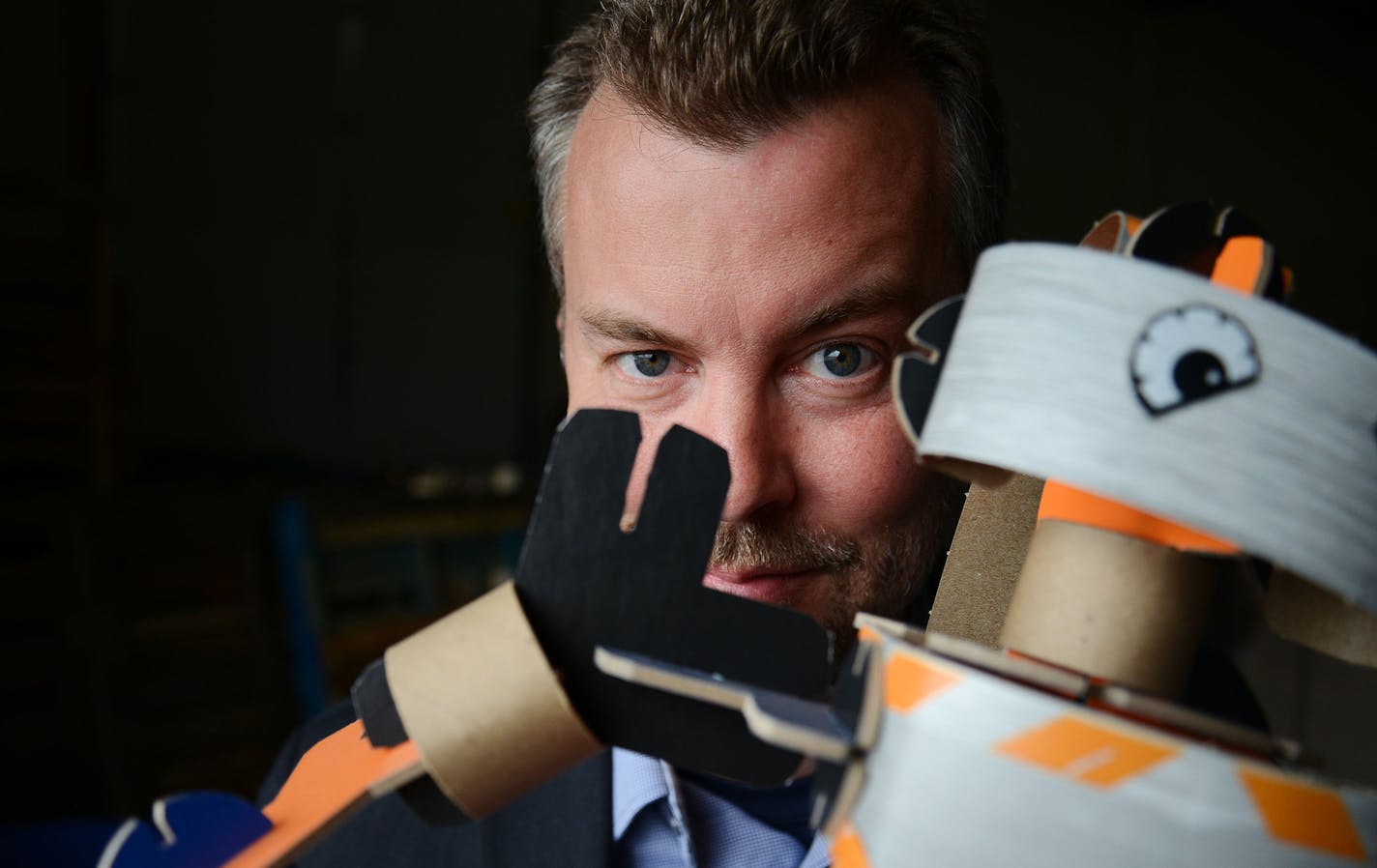 Founder, Inventor and CEO of YOXO Toys, Jeff Freeland Nelson poses with YOXO bot Orig at the YOXO production building in St. Paul, Minn., on Wednesday June 3, 2015. YOXO toys are built from eco-friendly materials, primarily recycled wood pulp. The toys include construction kits with suggested creations but can connect with all different kinds of objects. ] RACHEL WOOLF rachel.woolf@startribune.com