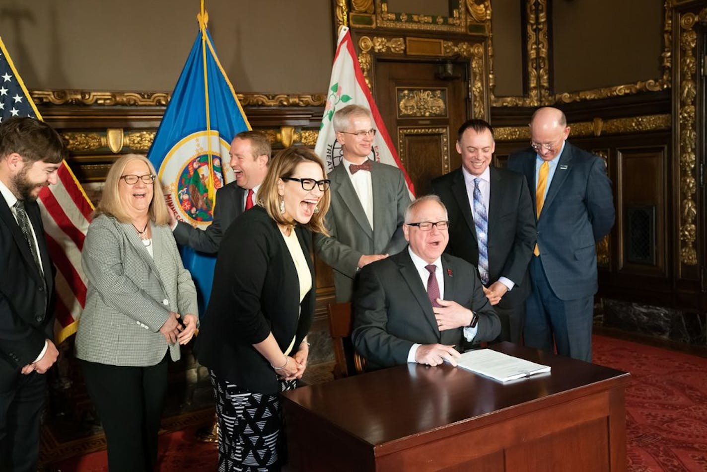 Governor Tim Walz and Lt. Governor Peggy Flanagan laughed after Sue Abderholden of NAMI thanked Star Tribune reporter Andy Mannix for his series of stories that spurred this legislation.