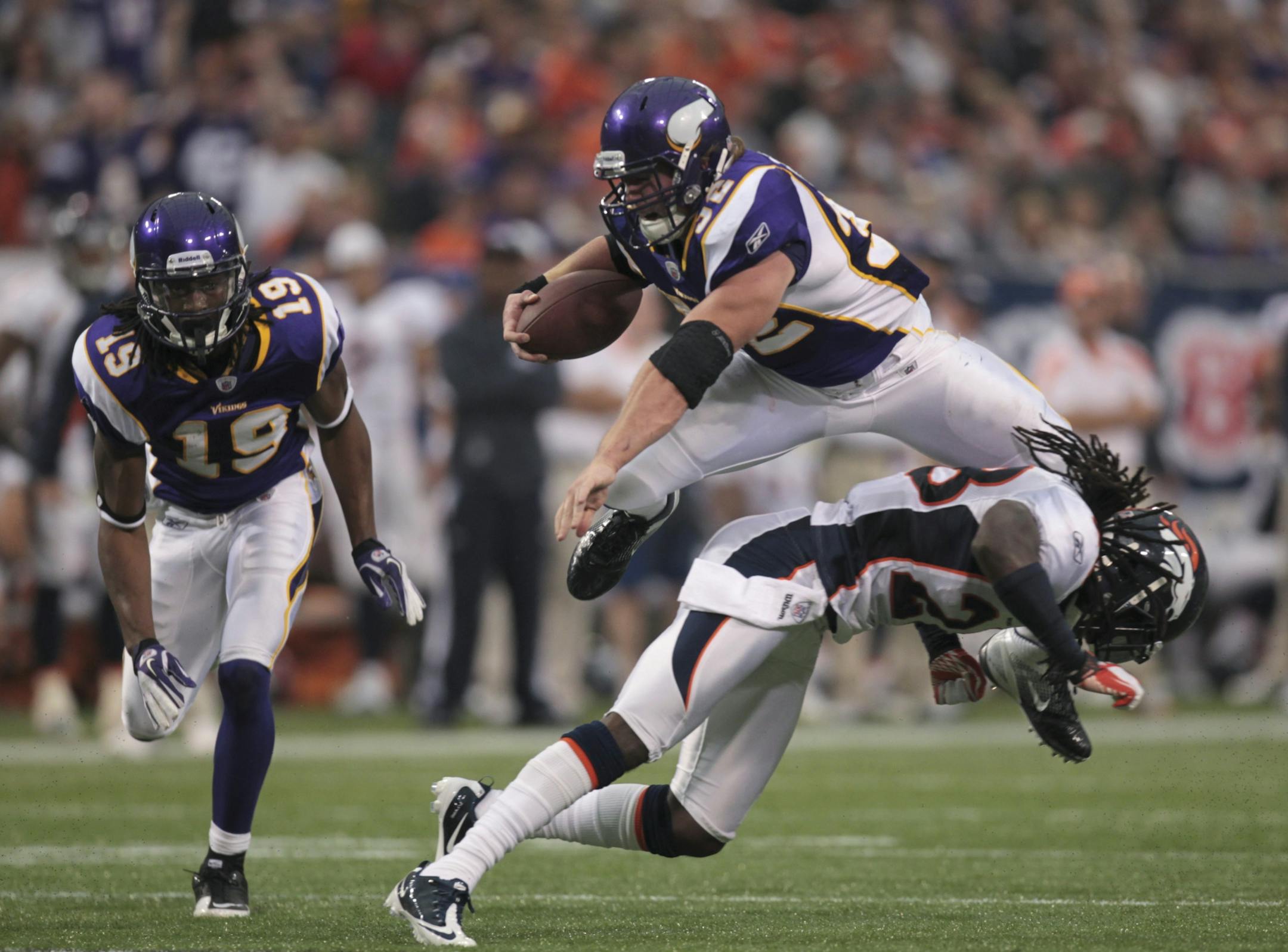 The Vikings' Toby Gerhart leapt over Denver's Quinton Carter while carrying the ball for 16 yards in the second quarter to the Denver 19 yard line. The Minnesota Vikings faced the Denver Broncos in an NFL game at Mall of America Field in Minneapolis, Minn. on Sunday afternoon, December 4, 2011.