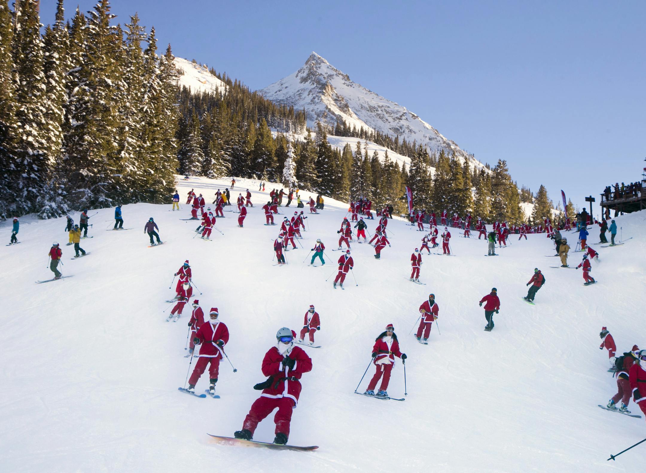 In this hand out image provided by Crested Butte Mountain Resort, shows participants dressed as Santas skiing from Uley's Ice Bar on Crested Butte Mountain, Crested Butte, Colo., for the first 'Santa Ski Crawl' on Saturday, Dec. 14, 2013. There were over 425 in participants in this event. (AP Photo/Crested Butte Mountain Resort, Nathan Bilow)