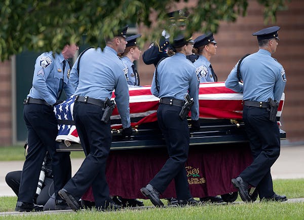 Law enforcement members accompany the casket of officer Jamal Mitchell at Maple Grove High School on Tuesday. 