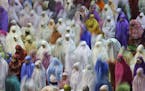 In this photo taken using slow shutter speed, Muslim women offer an evening prayer called "tarawih" marking the first eve of the holy fasting month of