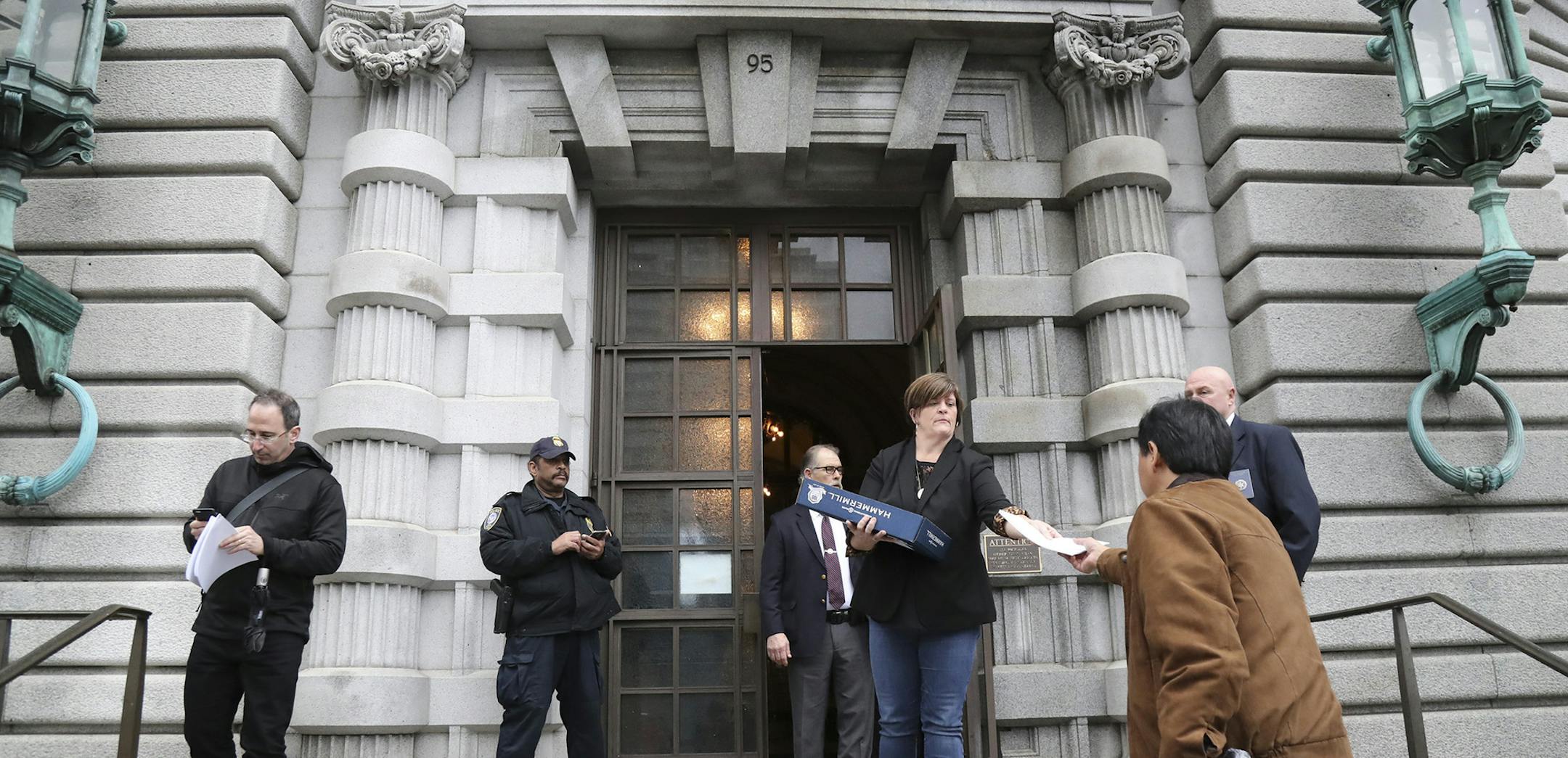 A court employee hands out the 9th Circuit Court of Appeals&#x2019; ruling against President Trump&#x2019;s travel ban, outside the courthouse in San Francisco, Feb. 9, 2017.