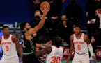 Minnesota Timberwolves' Karl-Anthony Towns (32) shoots as New York Knicks' RJ Barrett (9), Julius Randle (30) and Elfrid Payton (6) defend during the 