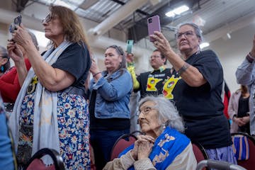 Carolyn Cavender Schommer, center, along with other tribal members, witnesses the signing of documents that officially marks the return of the state-o