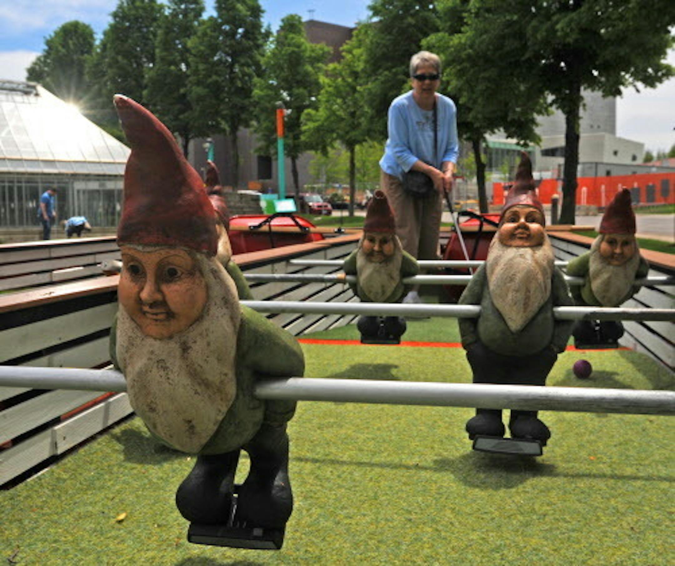 To celebrate the 25th anniversary of the Minneapolis Sculpture Garden Walker Art Center's Artist-Designed Mini Golf is now in play. Jan Tank of Milwaukee, Wisc played hole 6 the "Garden Gnome Foosball" which is a combination of foosball and mini golf. ]  Richard.Sennott@startribune.com Richard Sennott/Star Tribune. ,  , Minnesota Monday  6/3/13)  **   (cq)
