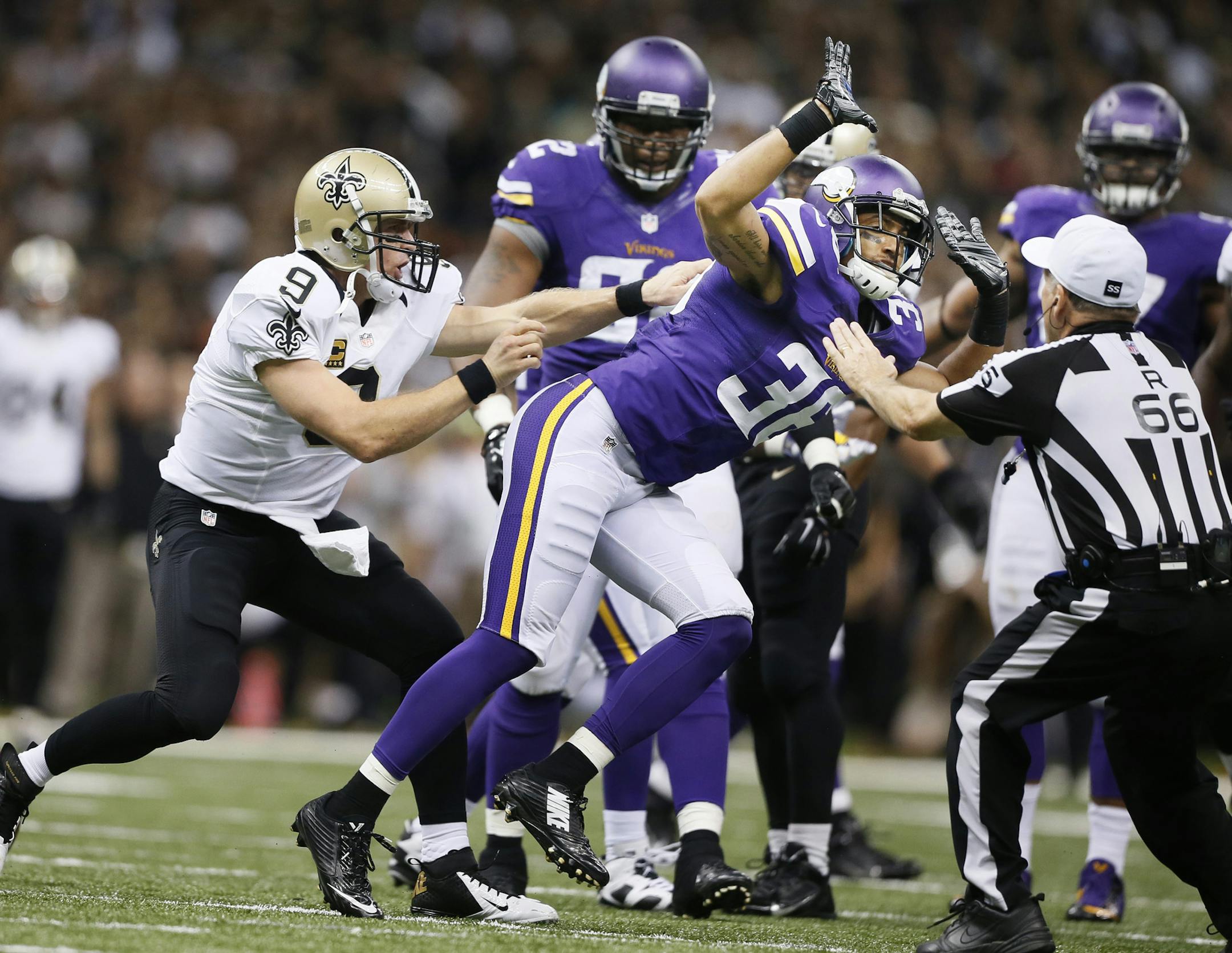 New Orleans Saints quarterback Drew Brees (9) goes after Minnesota Vikings strong safety Robert Blanton (36) after he was dumped on by Minnesota Vikings cornerback Captain Munnerlyn (24).