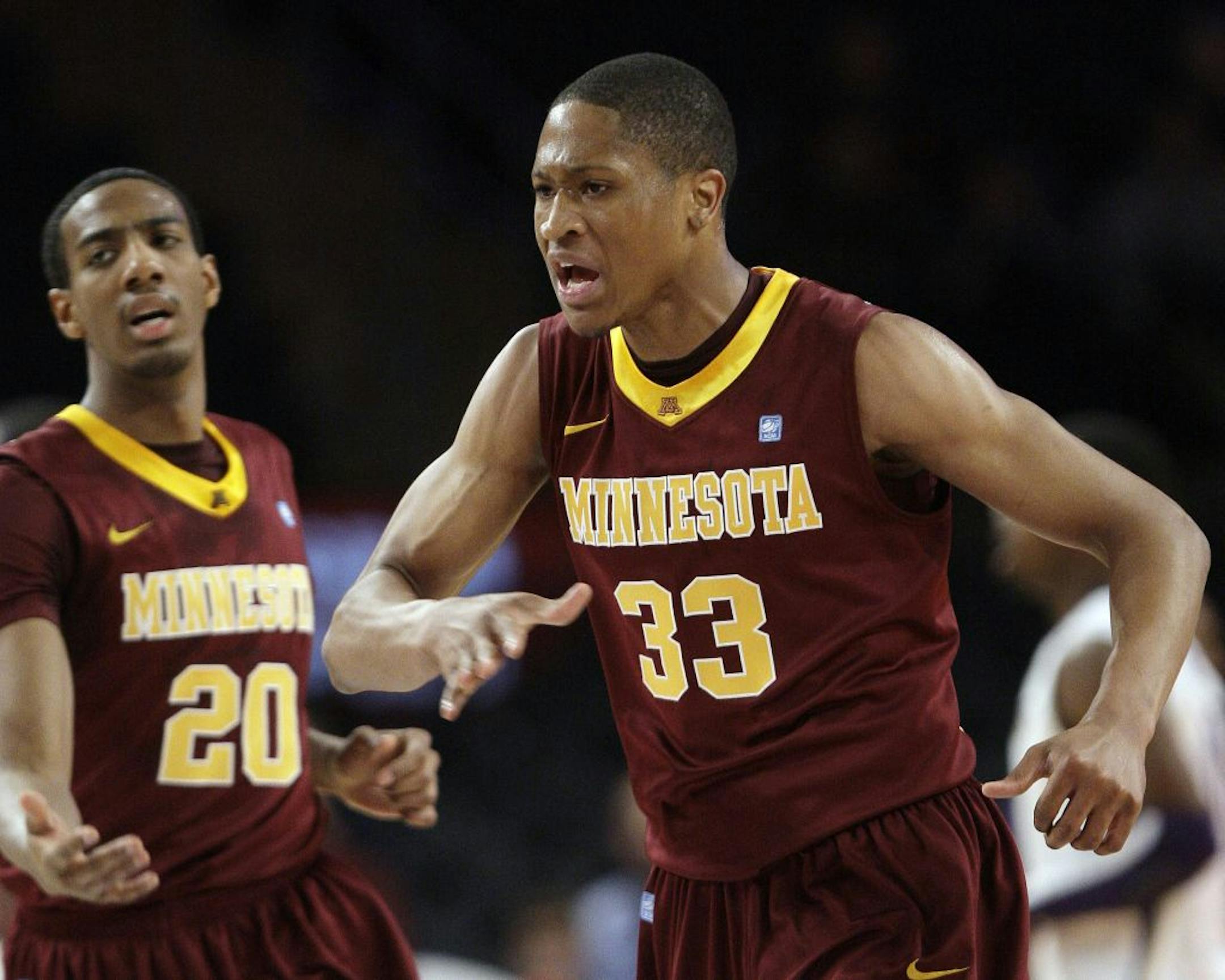 Minnesota's Rodney Williams (33) and teammate Austin Hollins (20) celebrate after Williams scored during the first half of an NIT men's college basketball tournament semifinal game against Washington, Tuesday, March 27, 2012, in New York.