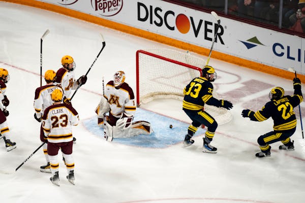Michigan players celebrate their first goal against the Gophers on Saturday night at 3M Arena at Mariucci.