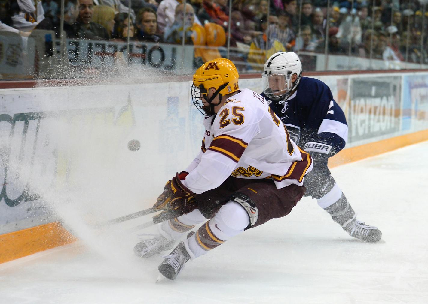 Gophers center Justin Kloos (25) tried to control the puck while being defended by Penn State Nittany Lions defenseman Connor Varley last February at Mariucci Arena.