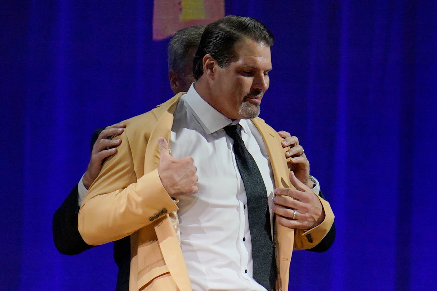 Steve Hutchinson, a member of the Pro Football Hall of Fame Centennial Class, receives his gold jacket Friday