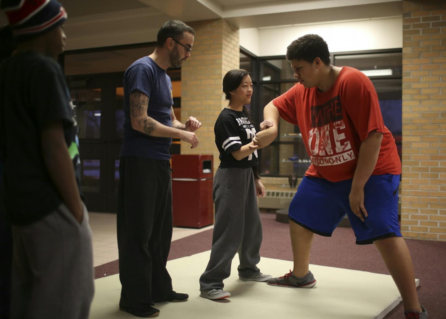 Jerome Diabe, left, watched as his martial arts instructor, Josh Countryman helped Sheng Vang practice a disabling hold on Brenden Hodge during their after school class Wednesday at Brooklyn Center High School. They are learning the Japanese karate discipline Ryukyu Kempo and meet twice a week.