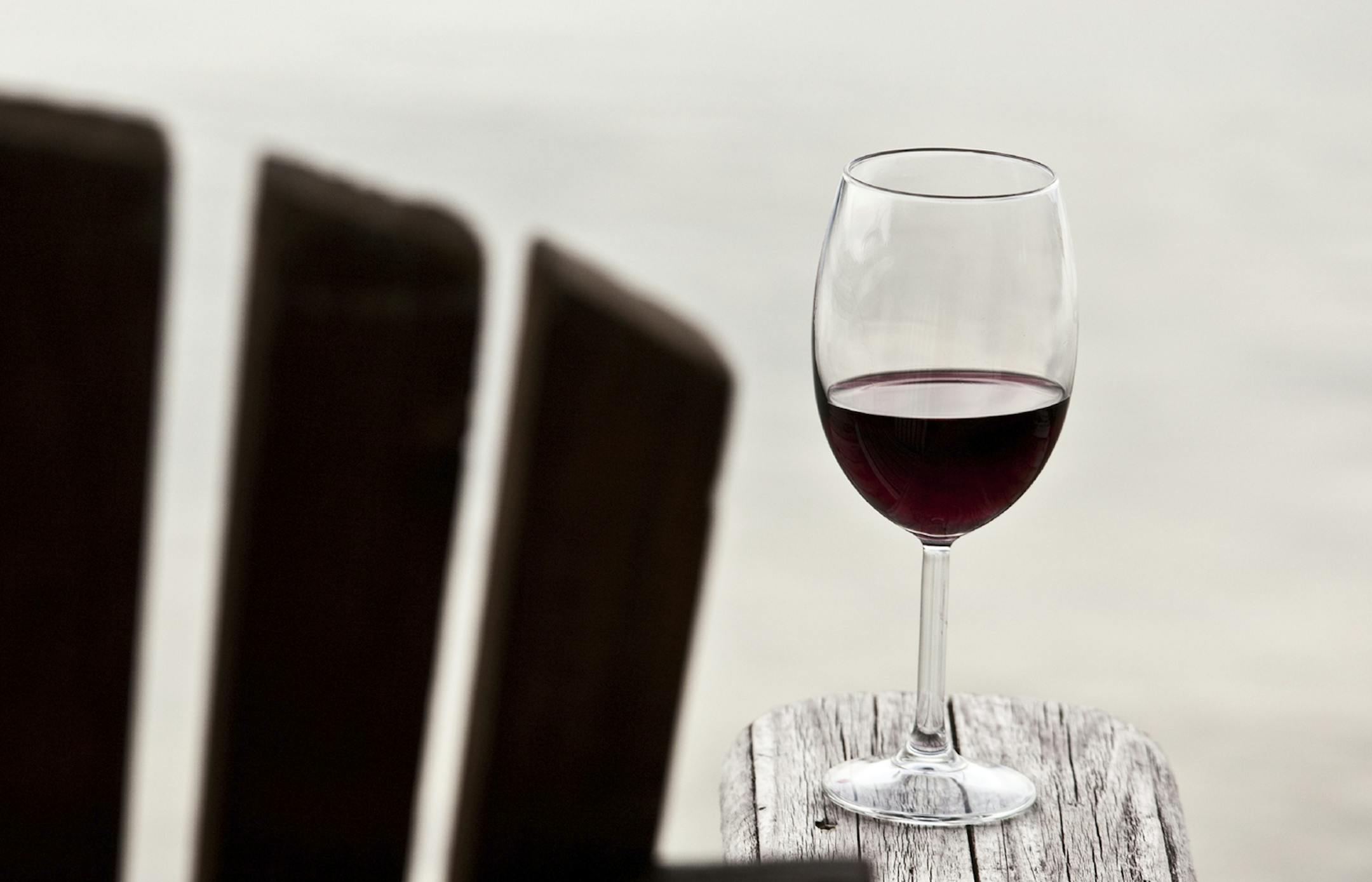 Glass of red wine on an adirondack chair. Istockphoto.com