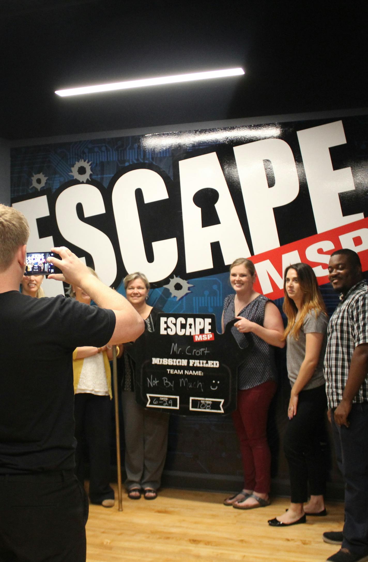 Mission Producer Evan Flolid takes a photo of a group of employees from the University of Minnesota Medical Center at Escape MSP in St. Paul. The group did not solve the mystery. Photo by Sharyn Jackson