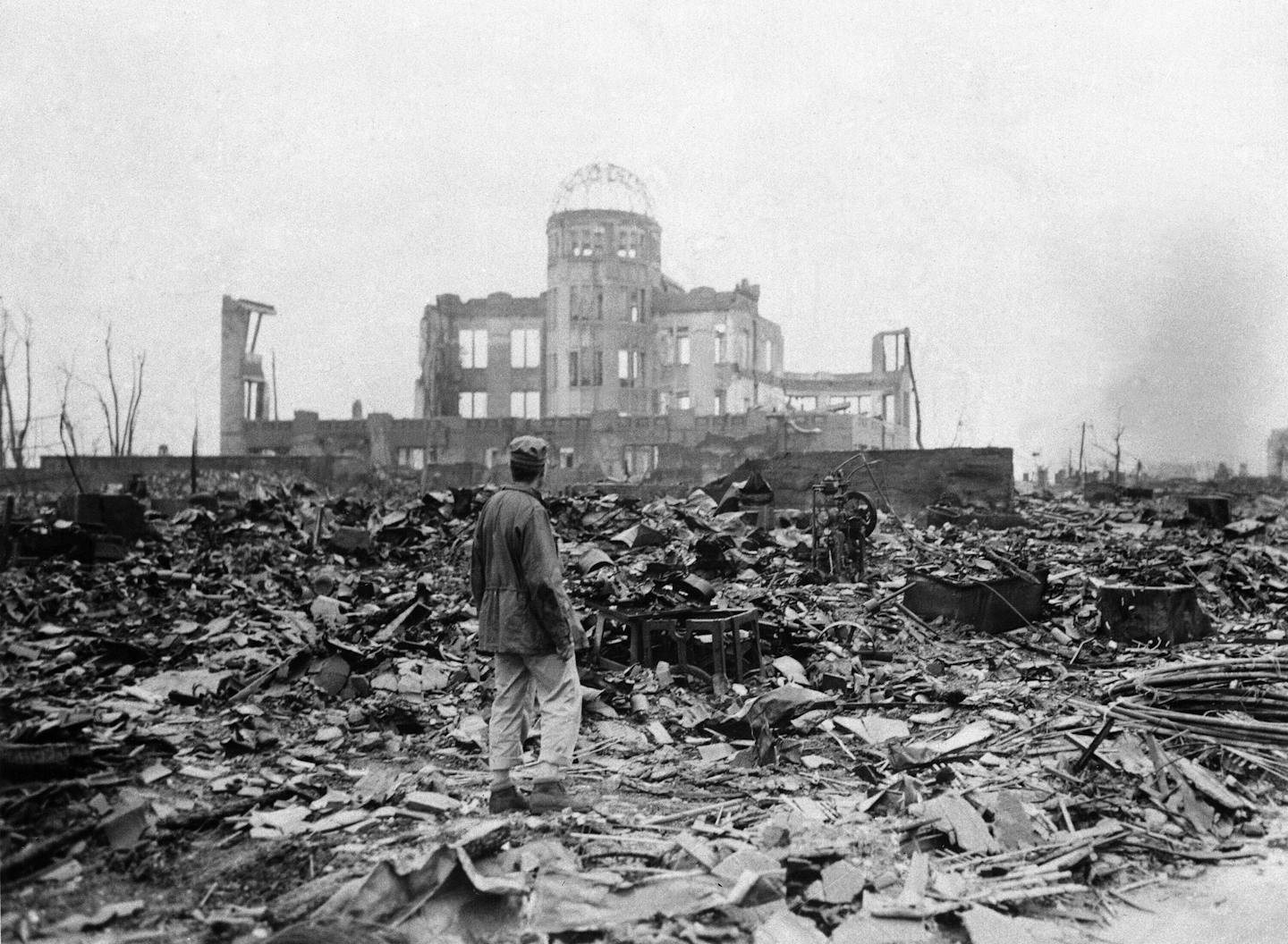 FILE - In this Sept. 8, 1945, file photo, an allied correspondent stands in a sea of rubble before the shell of a building that once was a movie theater in Hiroshima, western Japan, a month after the first atomic bomb ever used in warfare was dropped by the U.S. to hasten Japan's surrender. Many people exposed to radiation developed symptoms such as vomiting and hair loss. Most of those with severe radiation symptoms died within three to six weeks. Others who lived beyond that developed health p