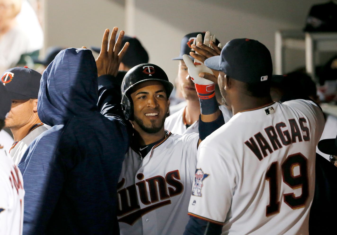 Minnesota Twins' Eddie Rosario, center, is congratulated by Kennys Vargas (19) and other teammates in the dugout after Rosario's two-run home run off Boston Red Sox's Koji Uehara during the fifth inning of a spring training baseball game, Wednesday, March 16, 2016, in Fort Myers, Fla. (AP Photo/Tony Gutierrez)