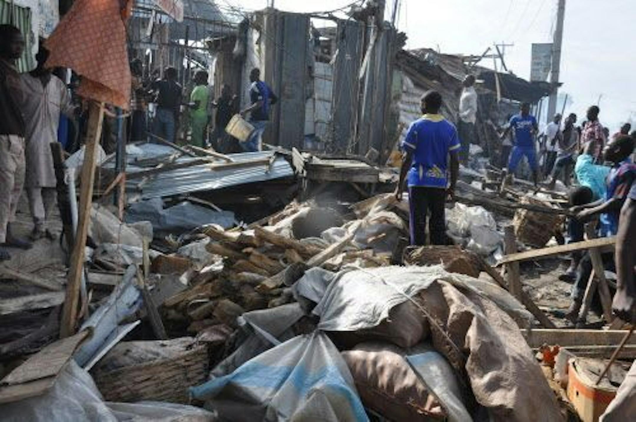 People gather at the scene of a car bomb explosion, at the central market, in Maiduguri, Nigeria, Tuesday, July 1, 2014.