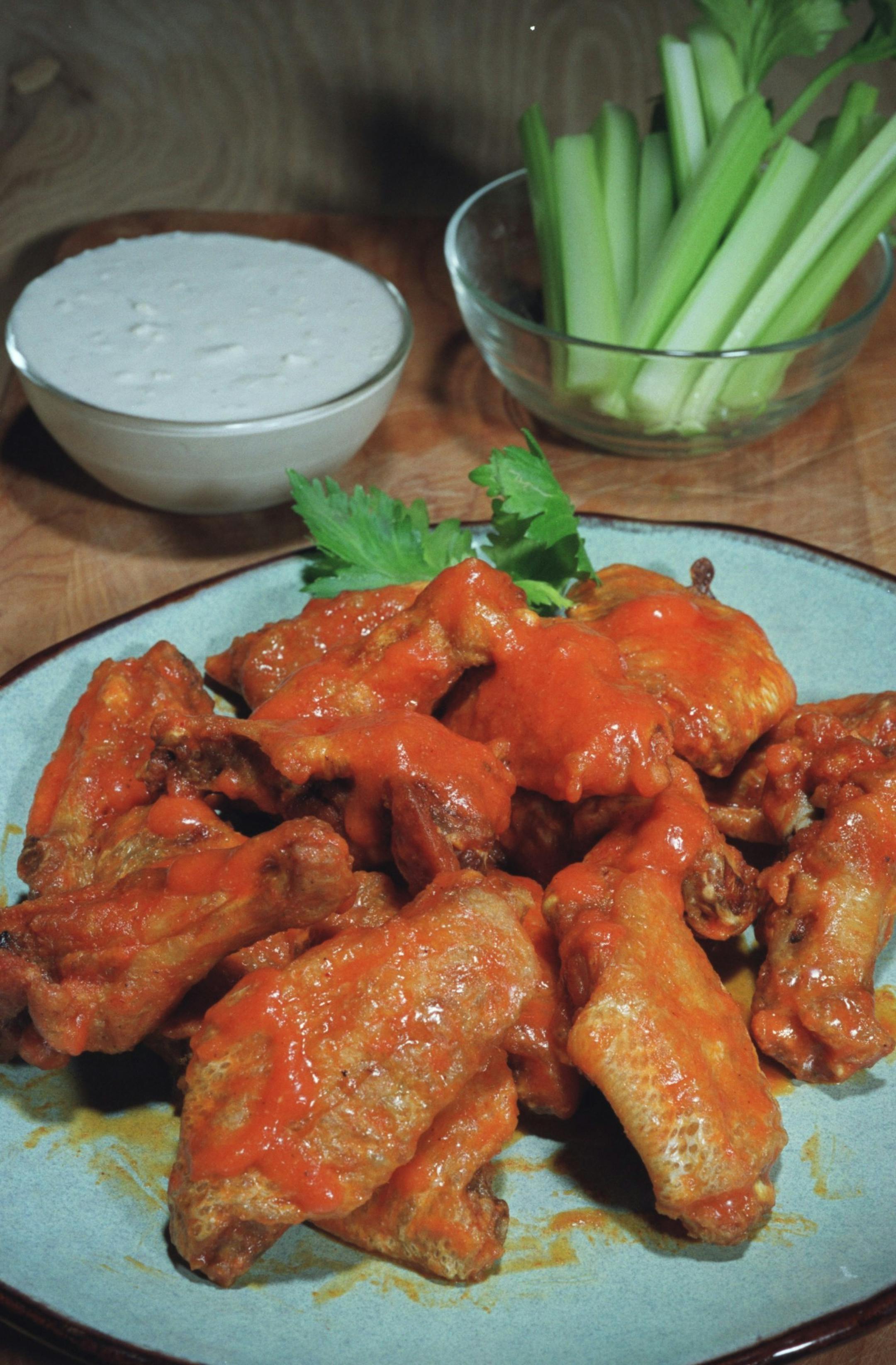 KRT FOOD STORY SLUGGED: WINGS KRT PHOTOGRAPH BY ED HAUN/DETROIT FREE PRESS (February 3) The traditional Buffalo-style chicken wings, fried an drenched in hot red pepper sauce mixed with melted butter, is a standard favorite recipe. (nk) 2003