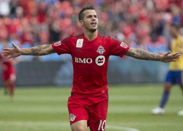 Toronto FC's Sebastian Giovinco celebrates after scoring his team's second goal against Colorado Rapids during the first half of the MLS soccer game i