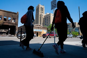 Broom-wielding volunteers walked up and down E. Lake Street, helping with clean-up, June 3.