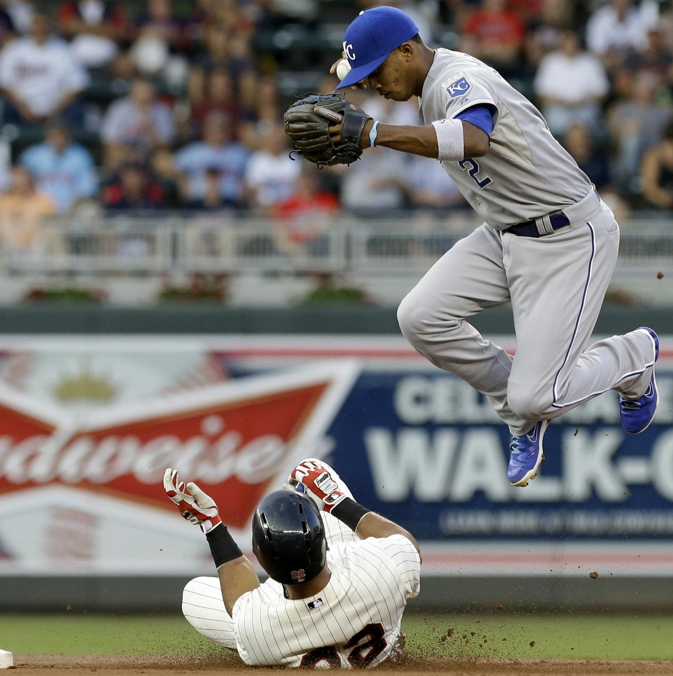 Kansas City Royals shortstop Alcides Escobar, right, jumps clear after the force-out at second on Minnesota Twins' Wilkin Ramirez. left, on a fielder's choice hit into by Justin Morneau in the first inning of a baseball game on Wednesday, Aug. 28, 2013, in Minneapolis. (AP Photo/Jim Mone)