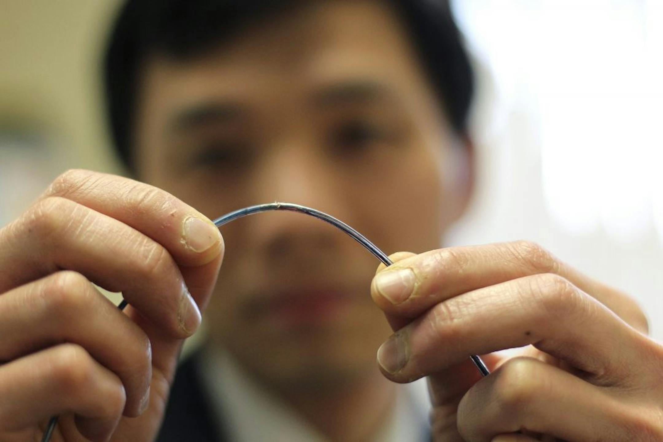 FILE -- Dr. Ernest Lau holds a Durata lead from a St. Jude Medical Fortify ICD heart defibrillator, in the Royal Victory Hospital, Belfast, Northern Ireland, April 13, 2012. Uncertainty is growing over statements by St. Jude Medical about the Durata wire's safety, underscored by its handling of a report that involved a Food and Drug Administration inspection of a plant that makes the Durata.