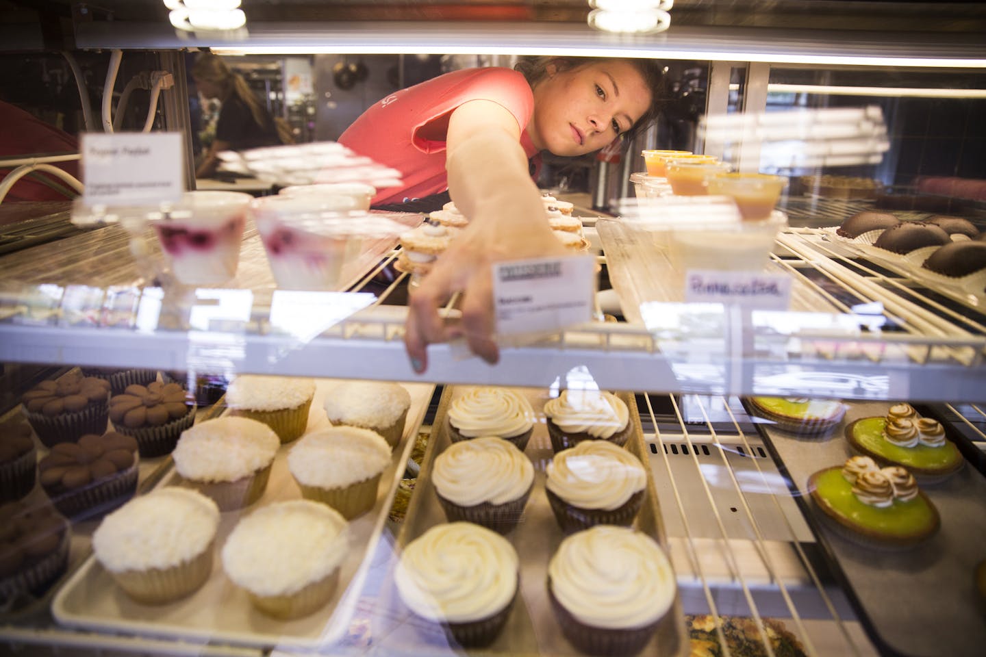 Barista Mollie Pohled fixes the bakery case signs at Patisserie Margo in downtown Excelsior on Tuesday, July 1, 2015. ] LEILA NAVIDI leila.navidi@startribune.com /