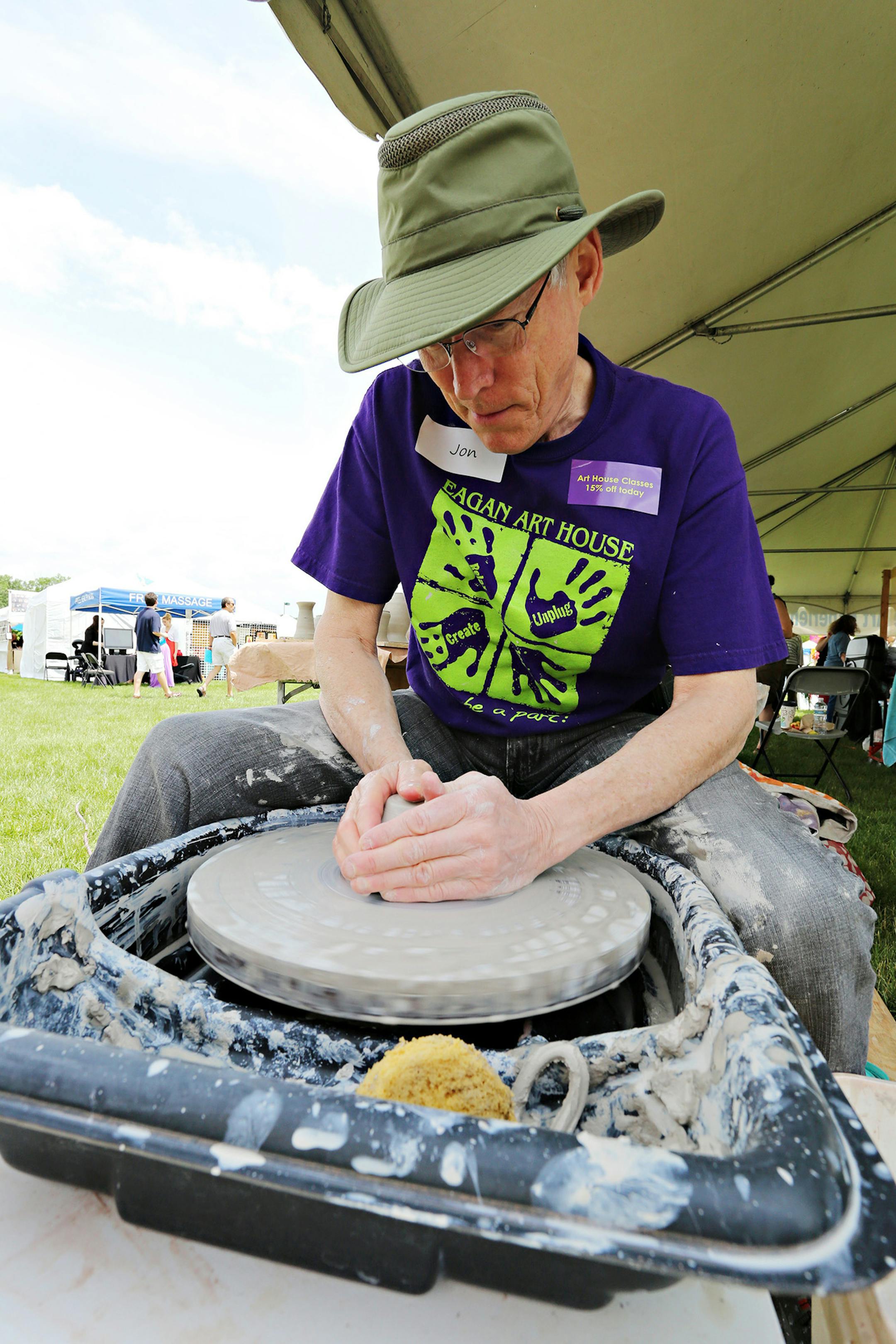 Eagan Art House staff member John Childers demonstrated how to use the wheel at the 2013 Eagan Art Festival. (Photo by Fred Miller)