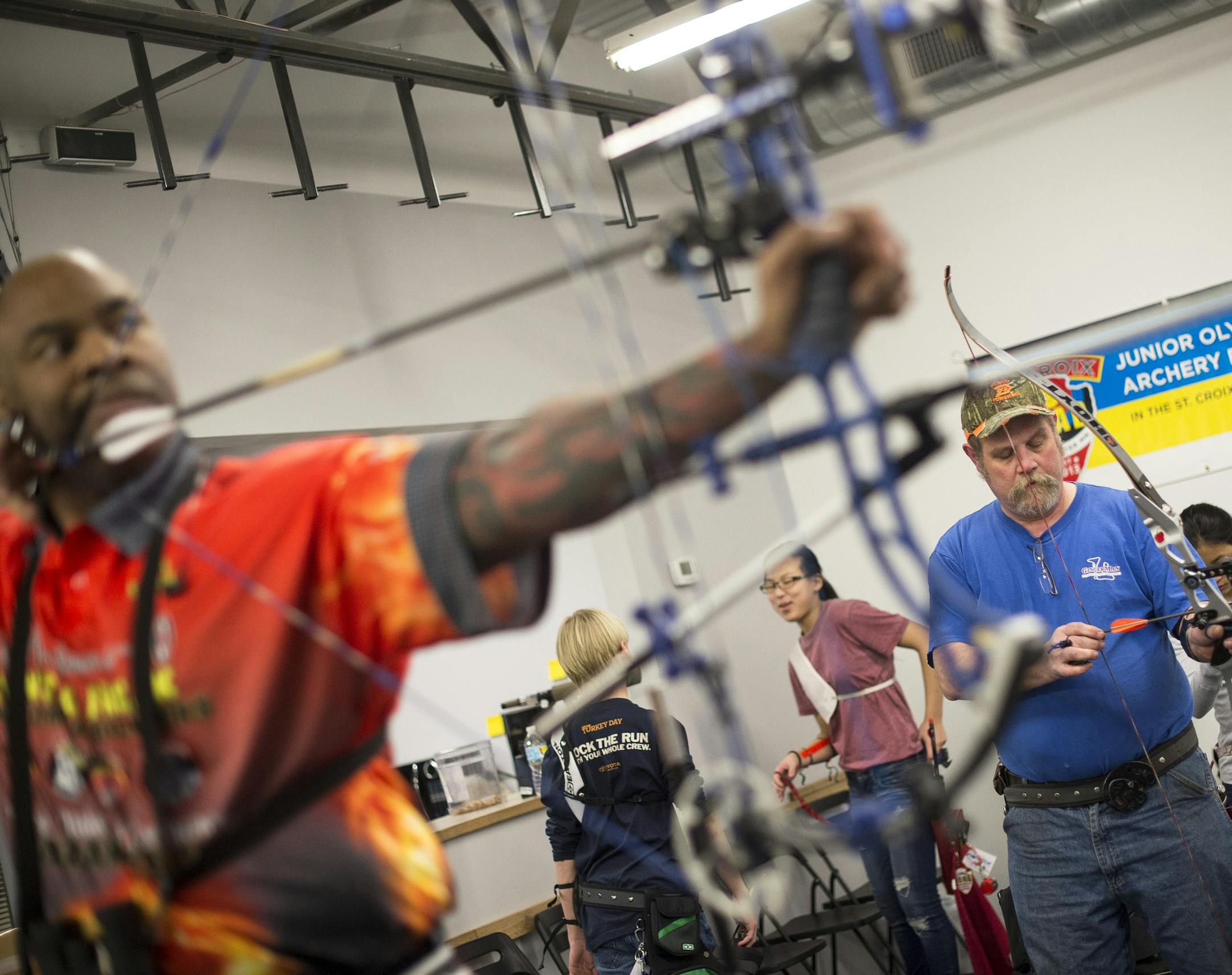Deshante Coleman, left, of Woodbury prepares to shoot an arrow at a target down range as Tim Bleed, of St. Paul, sets up for a shot on Tuesday night. ] (Aaron Lavinsky | StarTribune) Diane Kleinke and her family along with other archers practice shooting at the Minnesota NorthStar Archery Club in Woodbury. They were photographed Tuesday, Feb. 24, 2015.