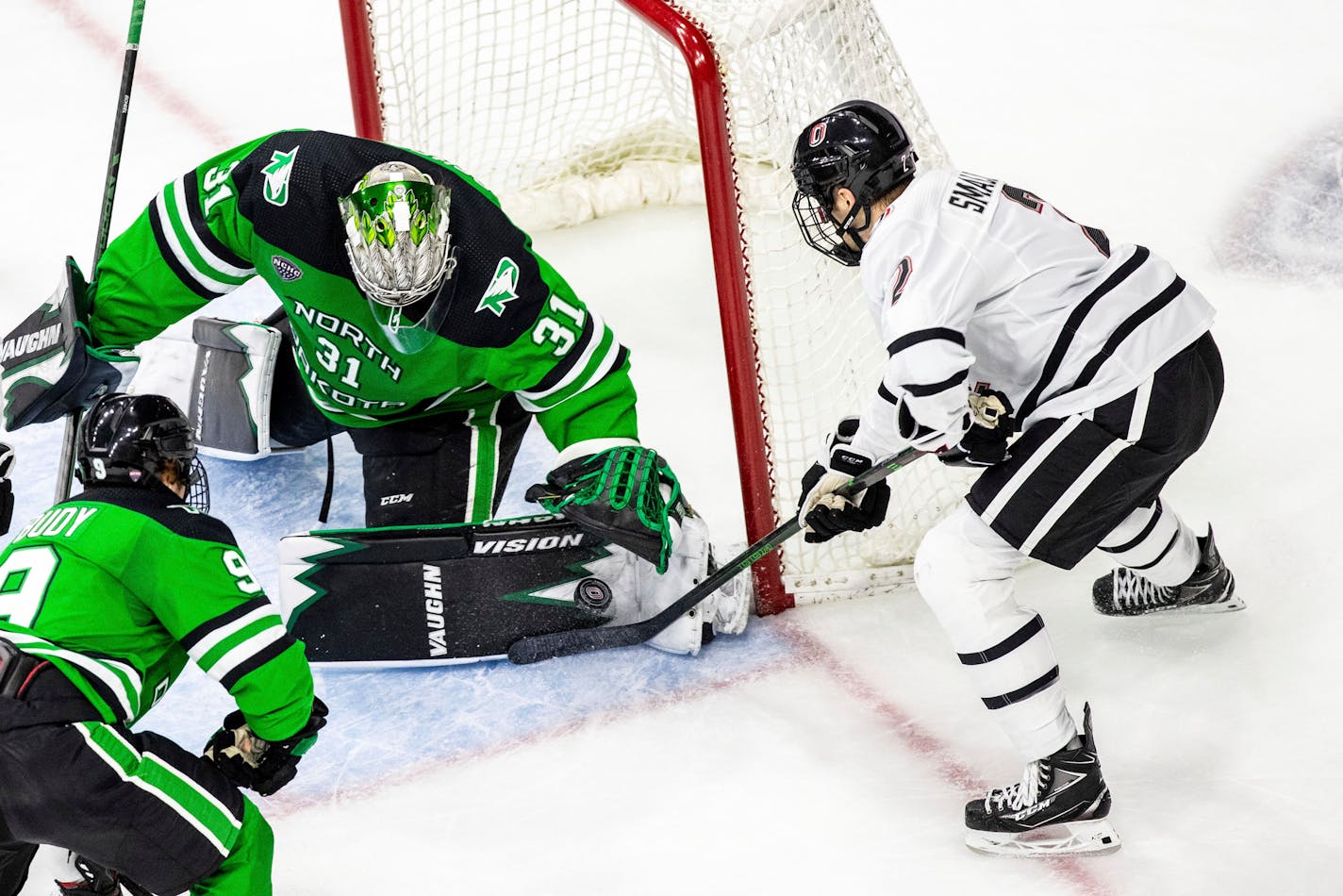 Omaha's Jason Smallidge tries to sneak a shot past North Dakota goalie Adam Scheel during the second period of a college hockey game Friday, Feb. 26, 2021. (Chris Machian/Omaha World-Herald via AP)