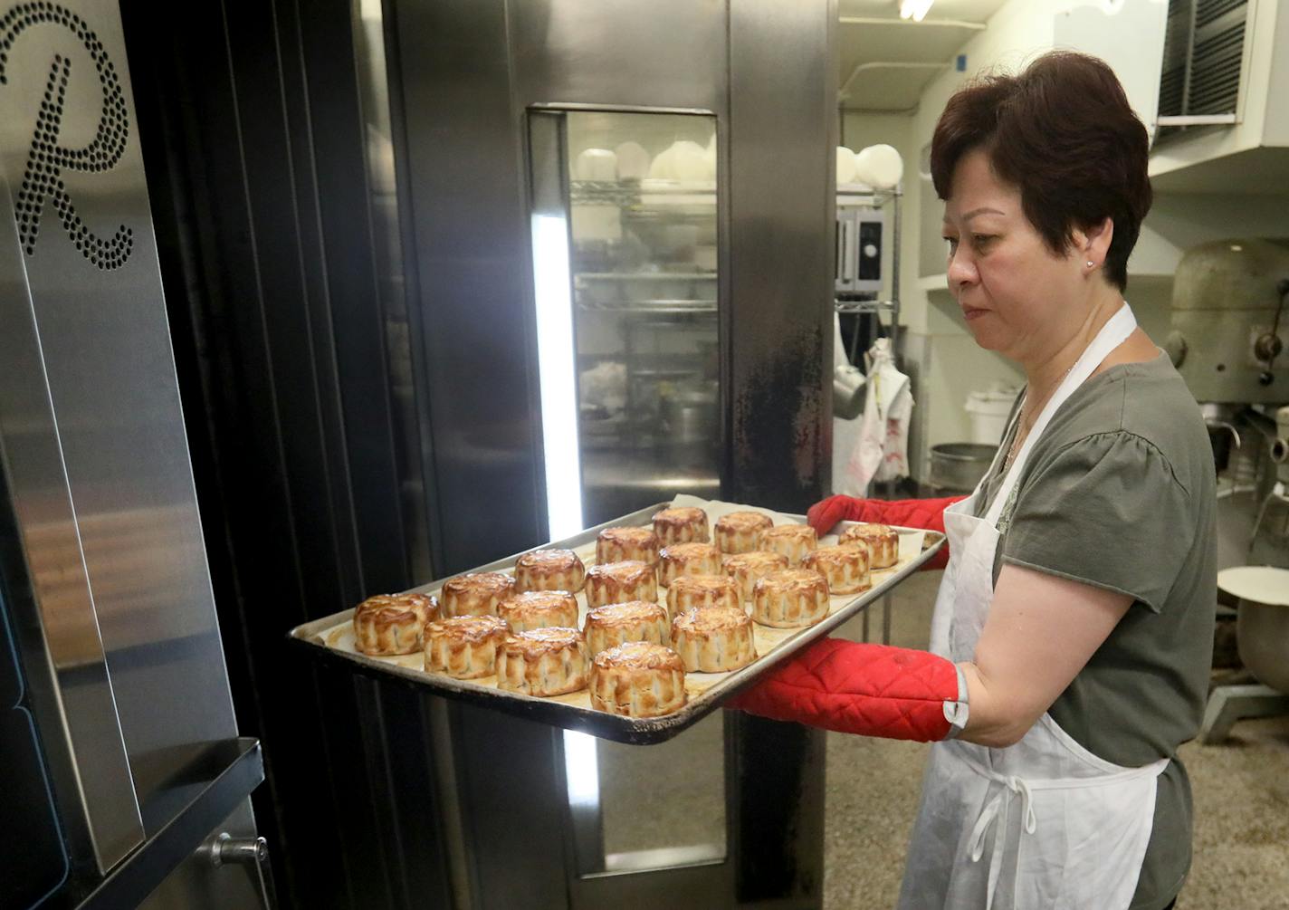 Pauline Kwan made mooncakes ahead of the lunar calendar harvest holiday that begins on Monday. Mooncakes are a specialty at the Mid-Autumn Festival and this is one of the only places in the Twin Cities where they are made. Here, Kwan, who has been making mooncakes for 35 years, removes baked mooncakes from the oven at Keefer Court Bakery and Cafe Wednesday, Sept. 18, 2018, in Minneapolis, MN.] DAVID JOLES &#xef; david.joles@startribune.com Michelle Kwan is taking over the running of Keefer Court