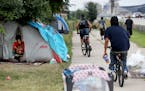 Kariece Wilson, 26, is among the more than 50 people who live at the large encampment along Hiawatha and Cedar Avenues and seen in her tent Tuesday, A
