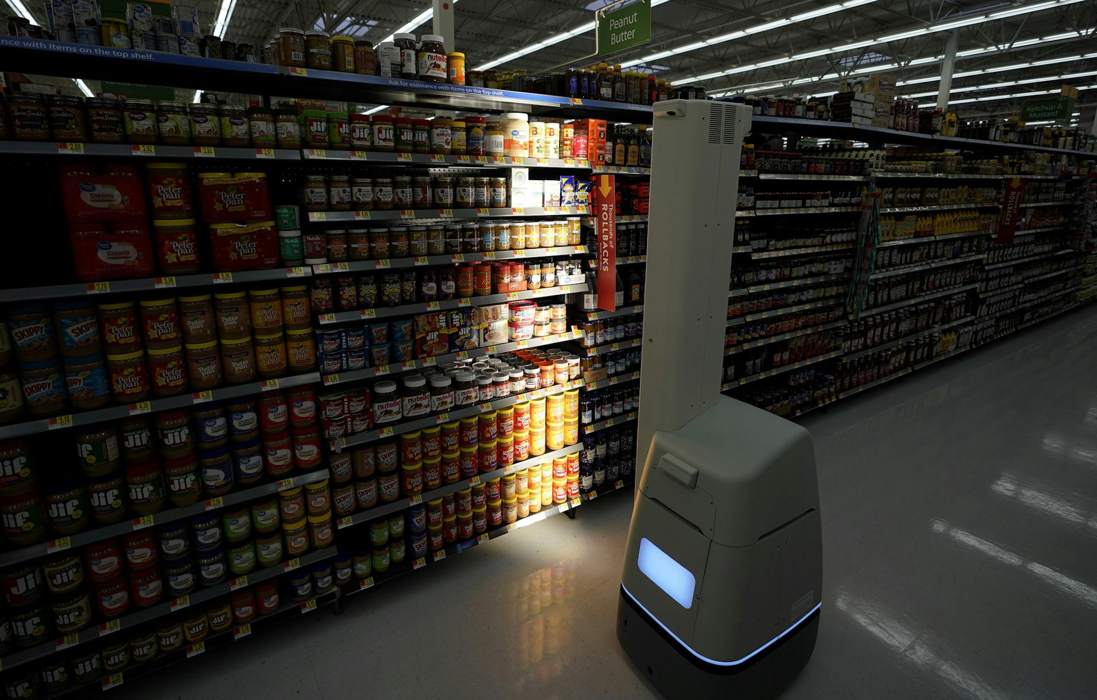 In this Friday, Nov. 9, 2018, photo a Bossa Nova robot scans shelves to help provide associates with real-time inventory data at a Walmart Supercenter in Houston. Scanning robots at a store in Houston as well as a cluster of others keep tabs of what’s on and not on the shelves and communicate that information to the automatic conveyor system that’s backed up to the truck bay. (AP Photo/David J. Phillip) ORG XMIT: NYBZ648