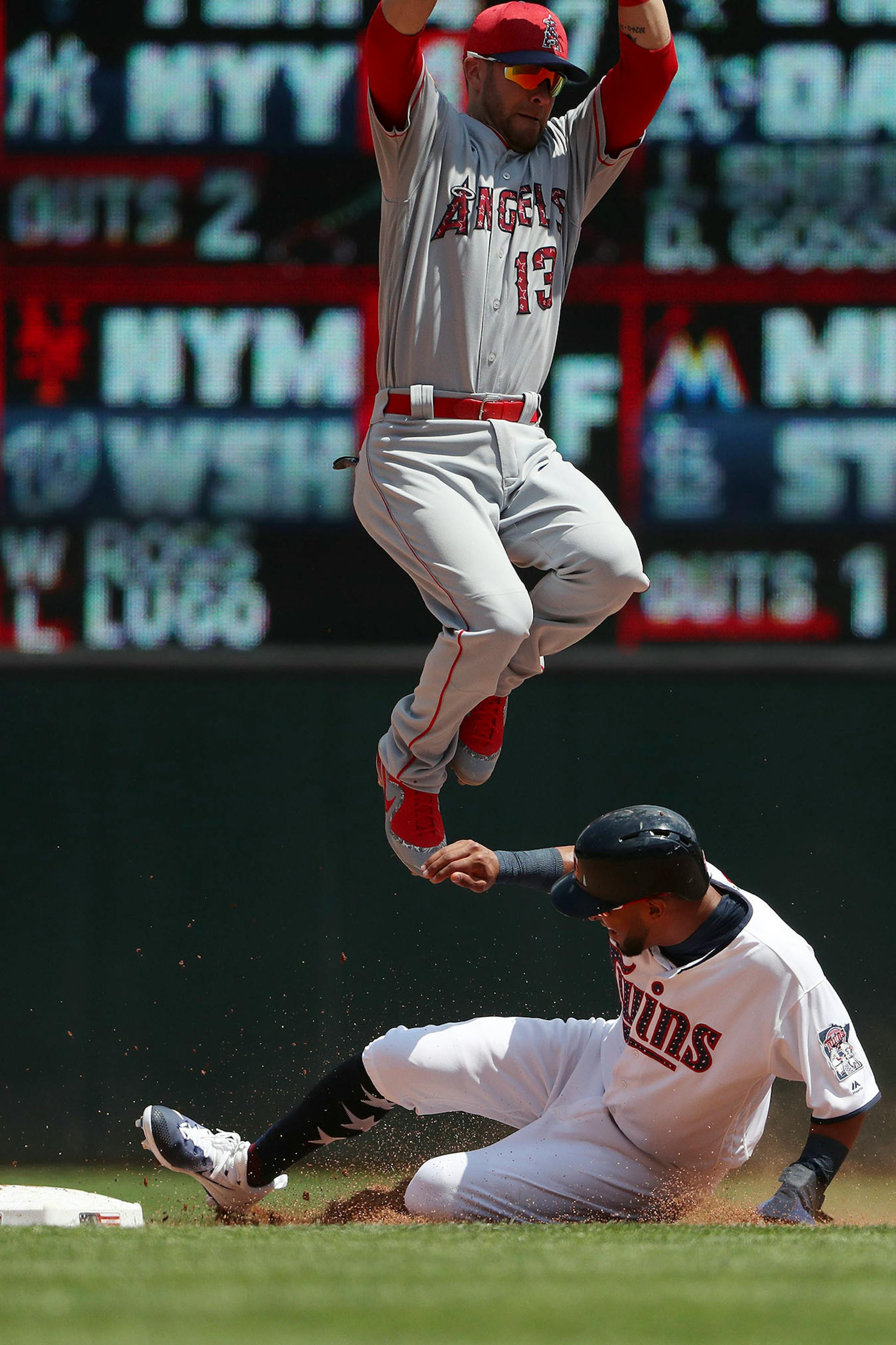 Los Angeles Angels left fielder Nick Franklin (13) jumped to try and get the out as Minnesota Twins left fielder Eddie Rosario (20) stole second base with Minnesota Twins catcher Chris Gimenez (38) batting in the fourth inning.