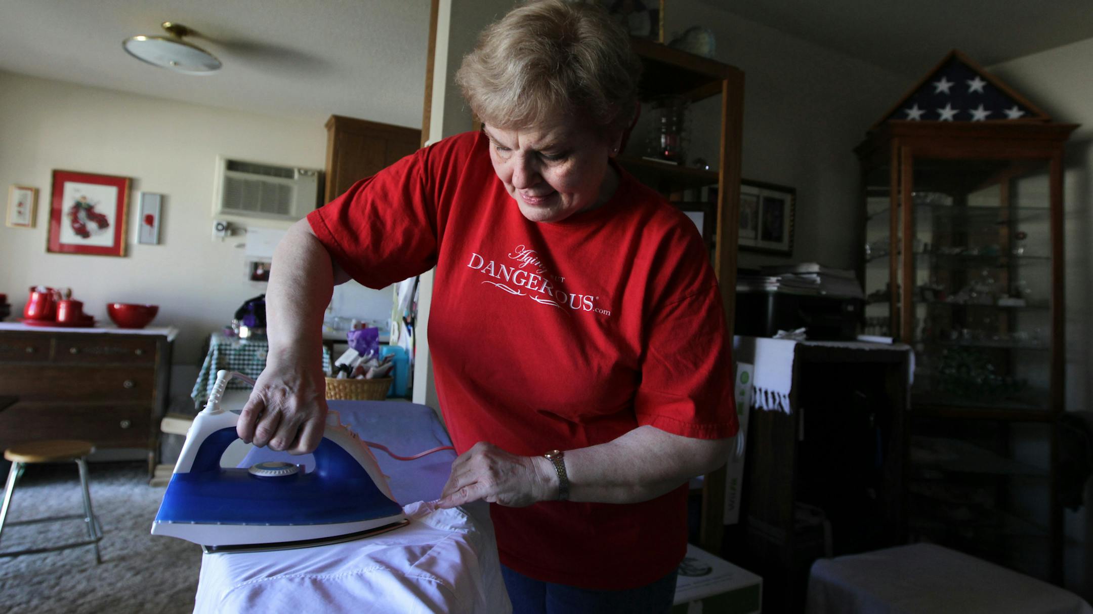 Donna Alexander, 67, ironed her security officer uniform. She likes her job, but the hours on her feet have taken a toll. She’s had multiple operations and can’t retire yet because she needs her health insurance.