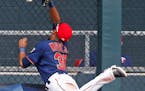 Minnesota Twins' left fielder LaMonte Wade, Jr., who was called up last week, hits the fence as he tries unsuccessfully to catch a fly ball for a home