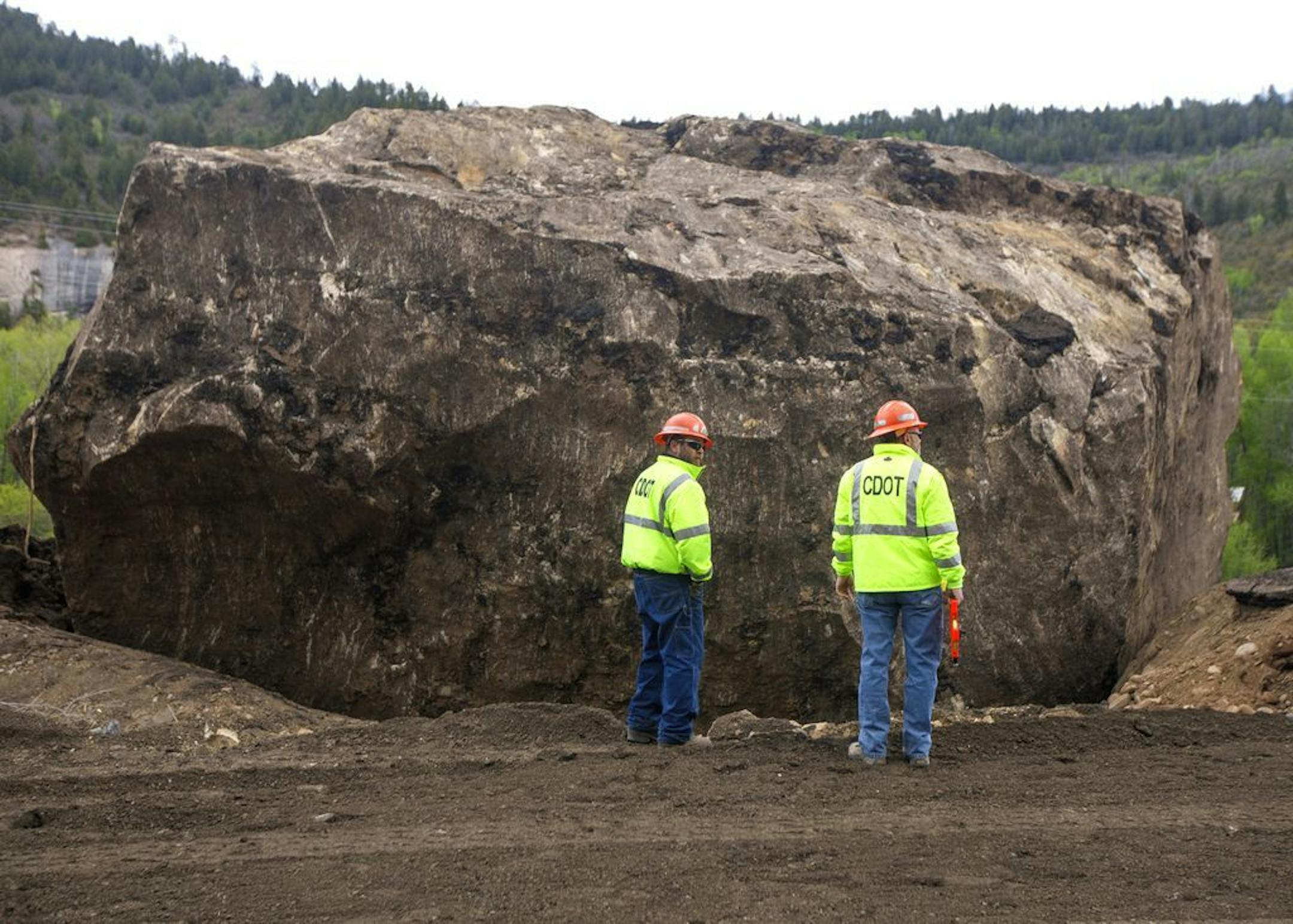 Colorado Department of Transportation official work to clean up Colorado State Highway 145 after two large boulders fell 1,000 feet from the nearby ridge and destroyed the pavement Monday, May 27, 2019 between Cortez and Tulleride, Colo.