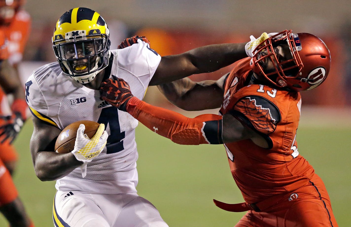 FILE - This Sept. 3, 2015, file photo, shows Michigan running back De'Veon Smith (4) being tackled by Utah linebacker Gionni Paul (13) during the second half of an NCAA college football game, in Salt Lake City. No. 24-ranked Utah has built a reputation as a defensive stalwart with an attacking front seven that harasses quarterbacks. But there may be a changing of the guard within the unit after the defensive backfield spearheaded the win against Michigan. (AP Photo/Rick Bowmer, File)