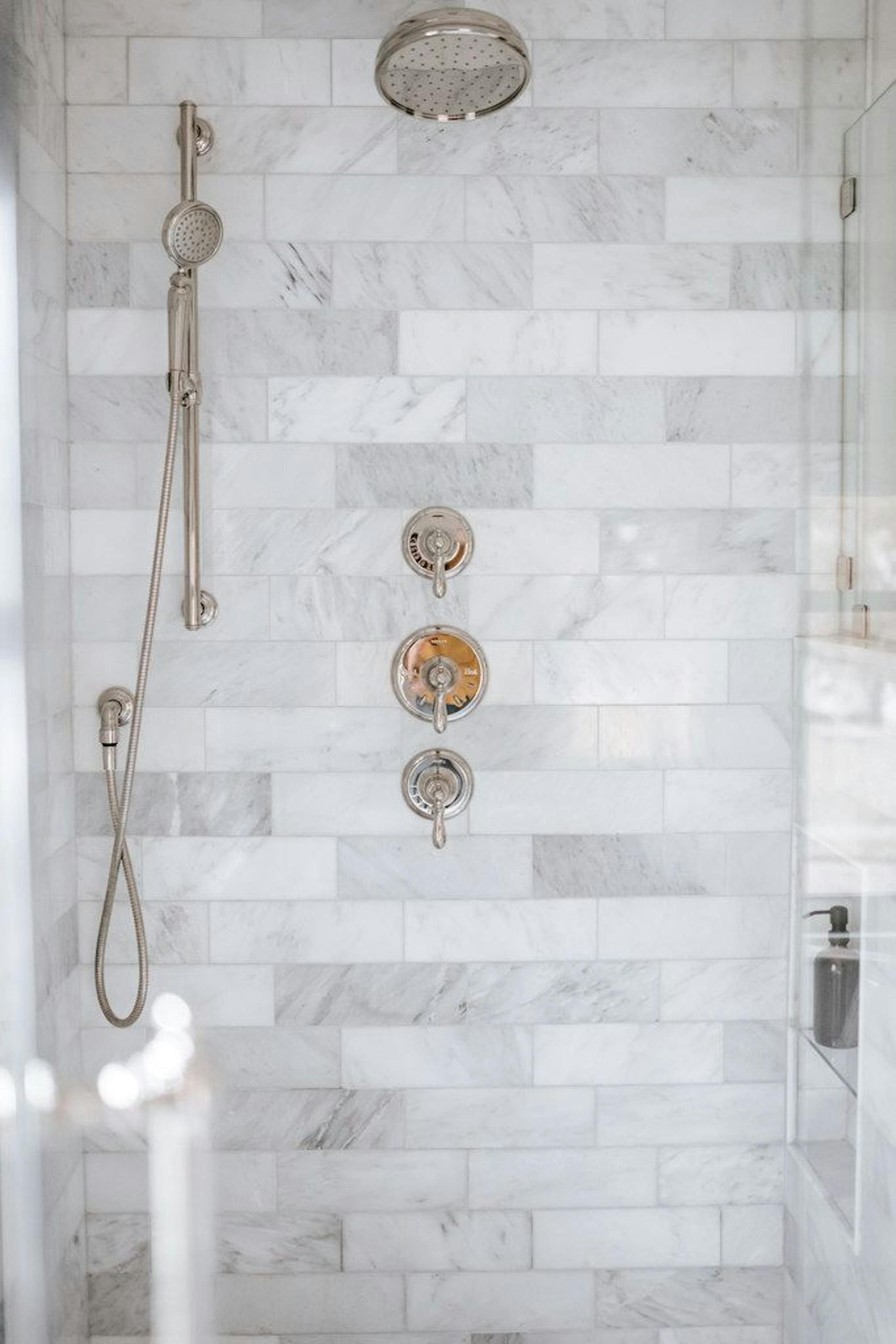 The new shower features marble tile and a large niche for shampoo bottles that's strategically located so it's out of sight and low enough to prop up a leg for shaving.